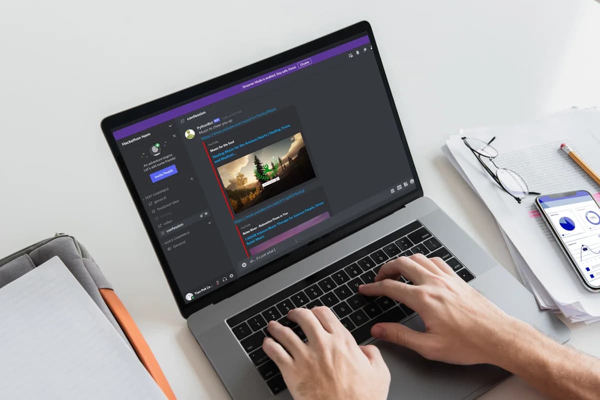 A laptop showing the MindfulHacks Discord bot sharing a YouTube music video.